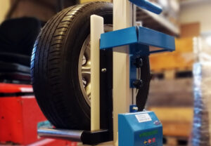 Pronomic elektrische ministapelaar tilt een autoband bij het vervangen van uw banden